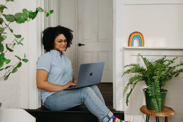 Woman relaxing on laptop sitting on a step
